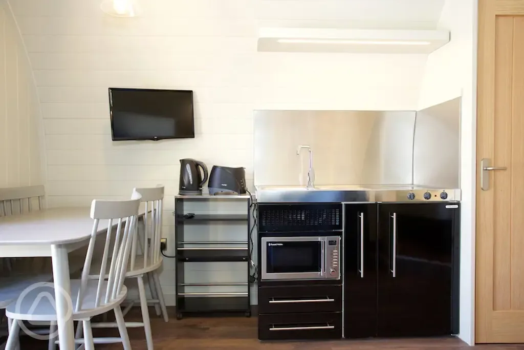 Superior pod kitchenette, dining table, and TV