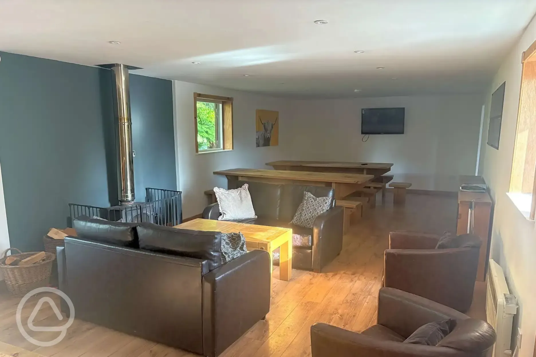 Communal area with tables, sofas, and a fire place
