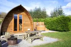 Premium ensuite glamping pod with private wood-fired hot tubs and picnic bench