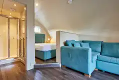 Superior ensuite glamping pod interior with double bed and sofa