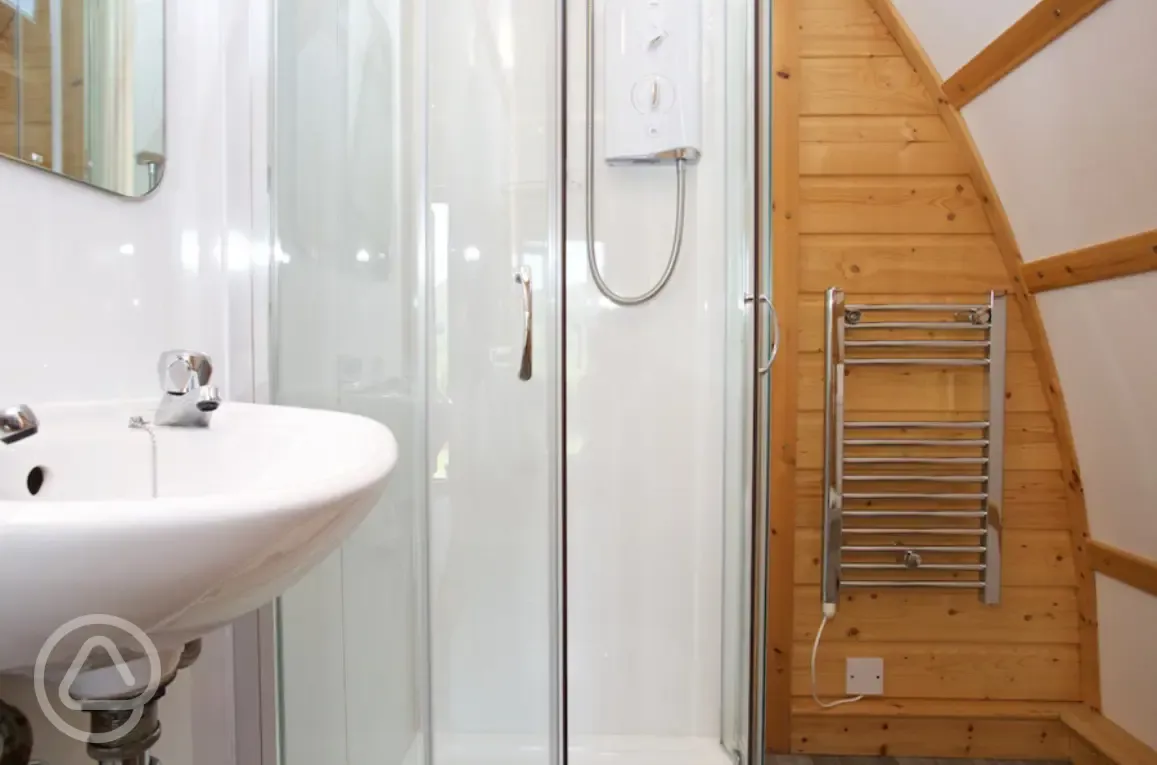 Premium ensuite glamping pod with a shower, heated towel rail, and sink