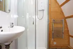 Premium ensuite glamping pod with a shower, heated towel rail, and sink