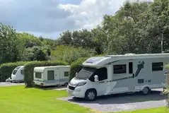 Fully serviced hardstanding pitches with hedging in between for privacy