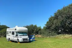 Electric grass pitches with 16 amp electric hook up and measuring 12m by 12m