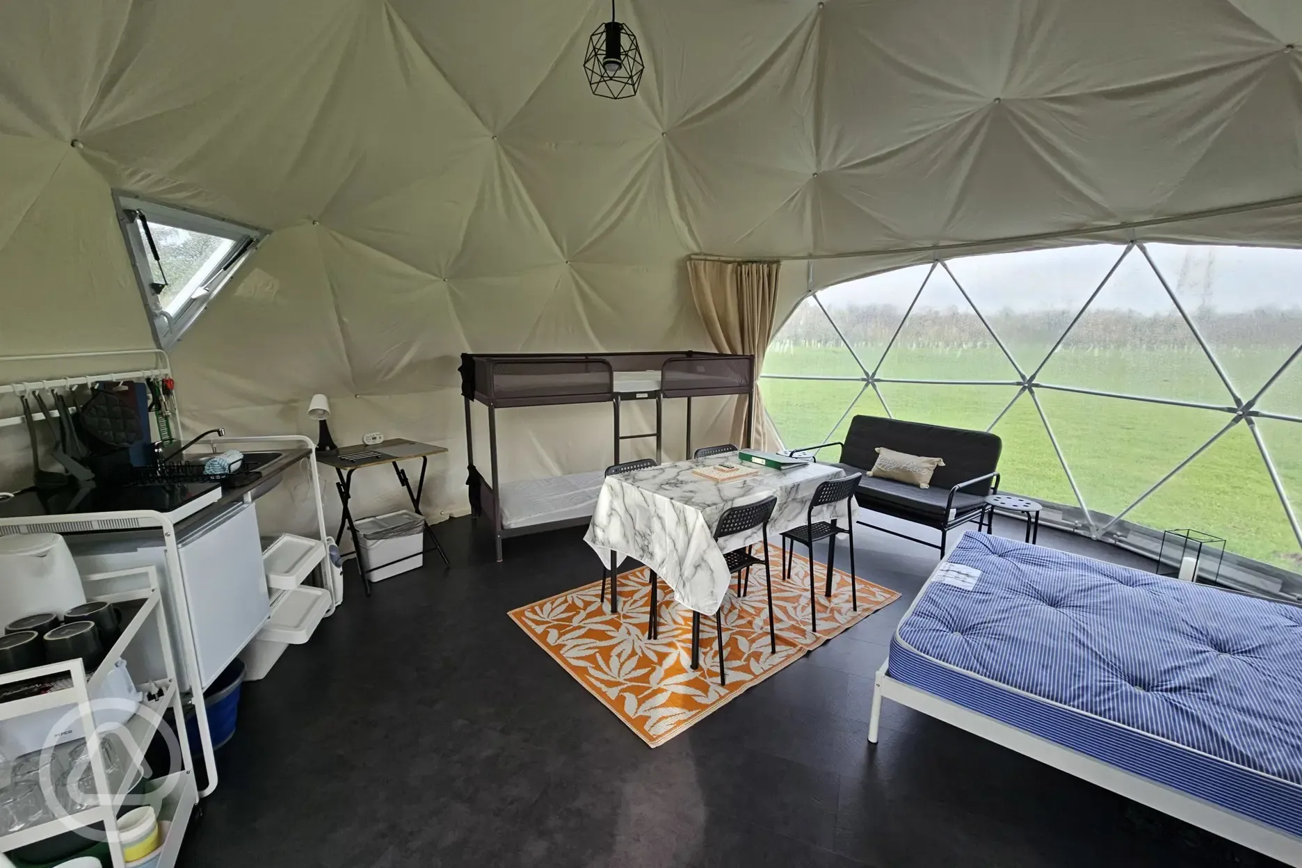 Geodome interior with double bed, bunk beds, and equipped kitchenette Geodome interior with double bed, bunk beds, and equipped kitchenette