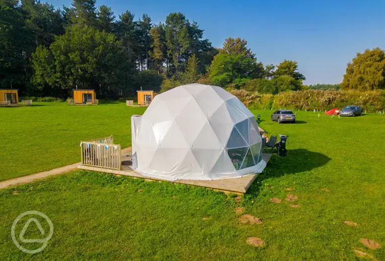 Geodome exterior with camper chairs and decking at Sherwood Pines Campsite