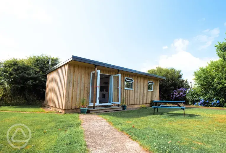 Glamping cabin with a picnic bench