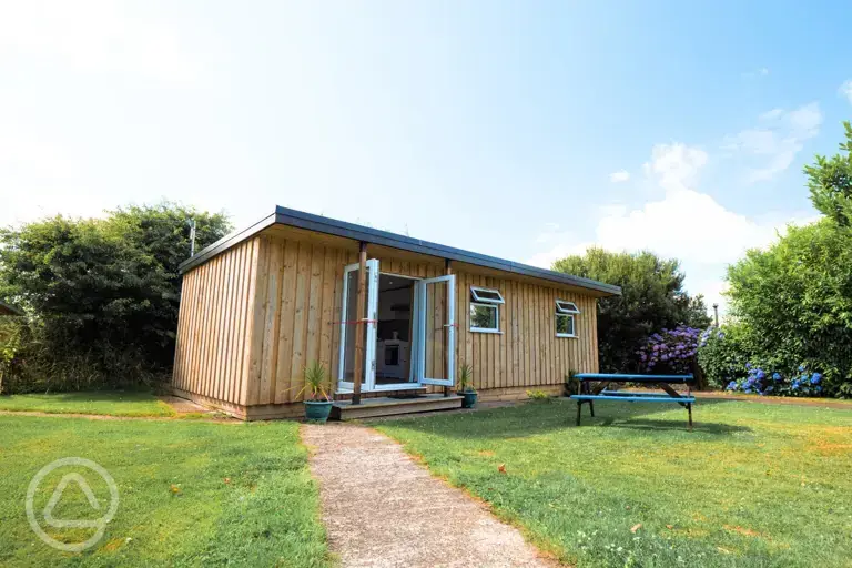 Glamping cabin with a picnic bench