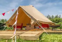 Main field bell tent with a double bed and two single futon beds