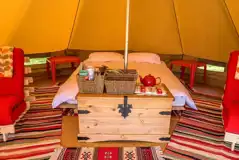 Main field bell tent with a double bed and two single futon beds