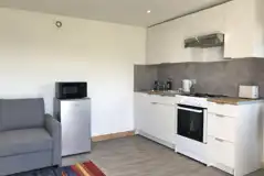 Glamping cabin kitchen with fridge, microwave, cooker, sink, kettle and toaster