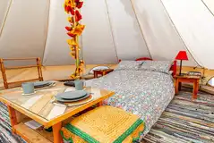 Furnished bell tent with a double bed and bedding