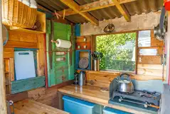 Yurt camp kitchen with a stove, kettle and cooking equipment