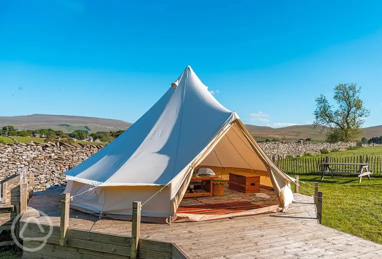 Bell tent on a decking area with a picnic bench