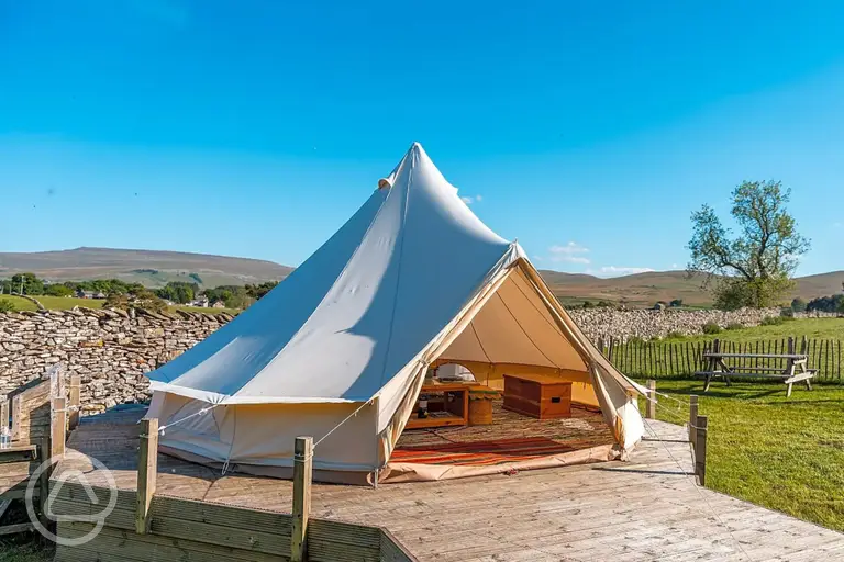 Bell tent on a decking area with a picnic bench