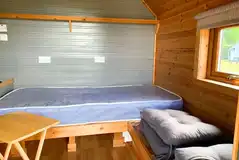 Octo pod interior with single bed, kettle, fridge, toaster and TV