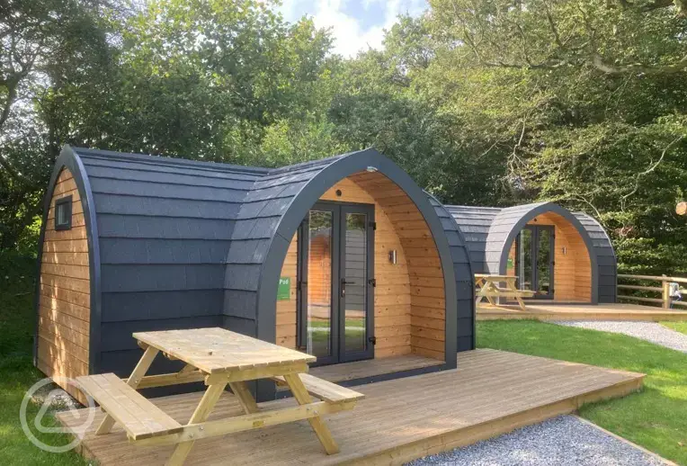 Orchard pods with small decking areas and picnic benches