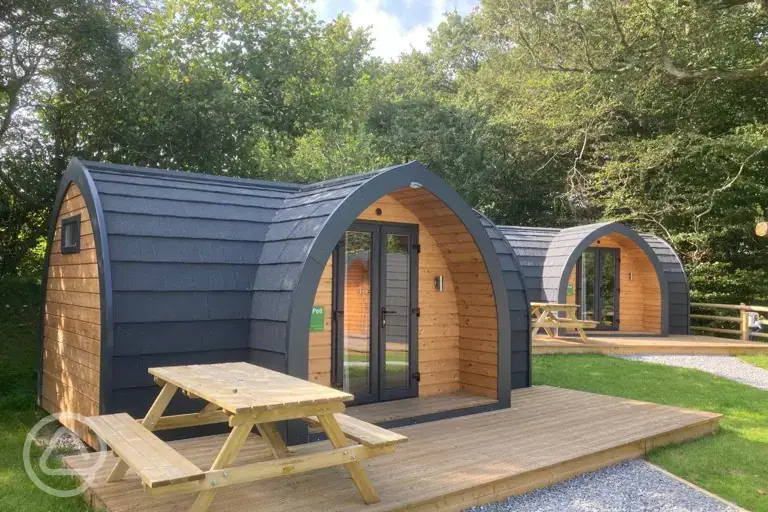 Orchard pods with small decking areas and picnic benches