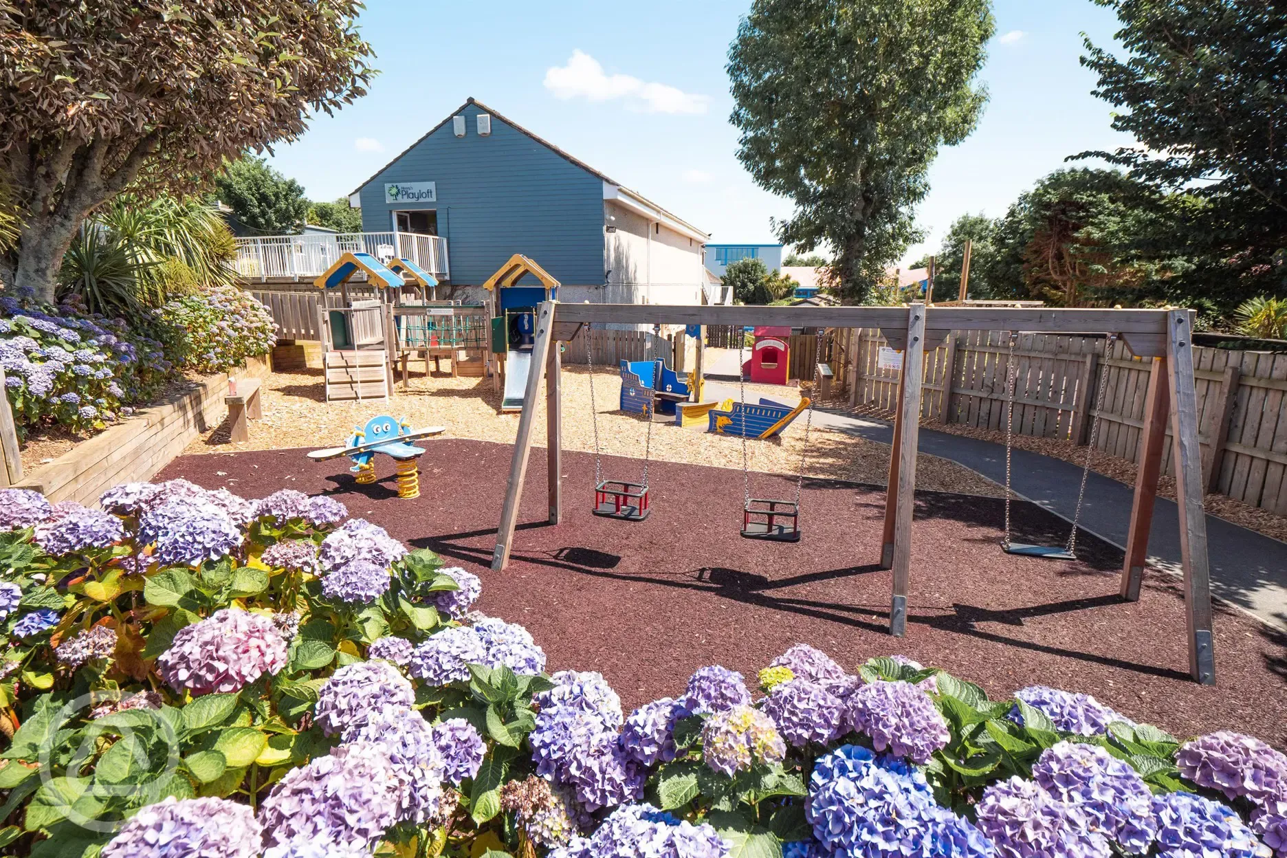 Children's play area with swings, slide and climbing frame