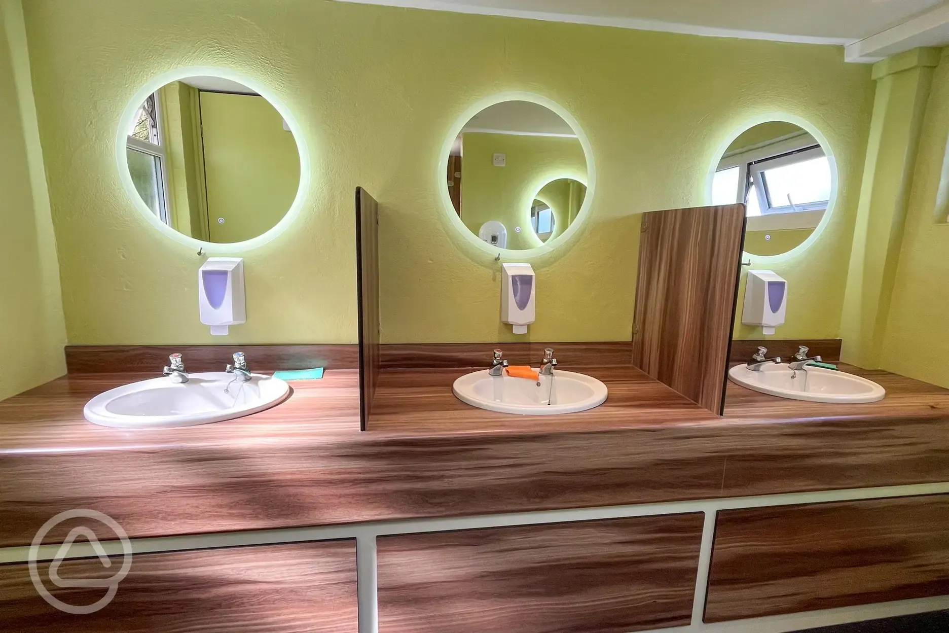 Facilities block interior with lit up mirrors and handwashing sinks