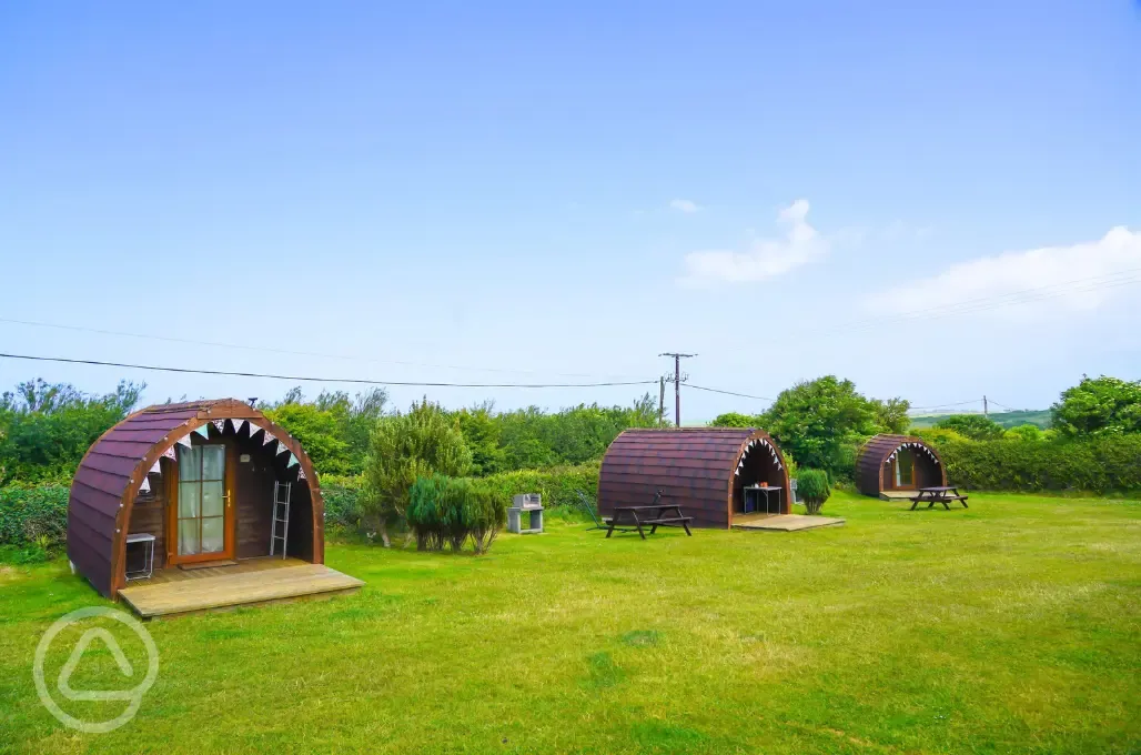 Overview of three of the log pods with decking and seating at Tollgate Farm