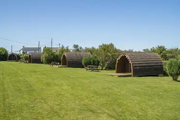 Glamping pods with decking and picnic benches