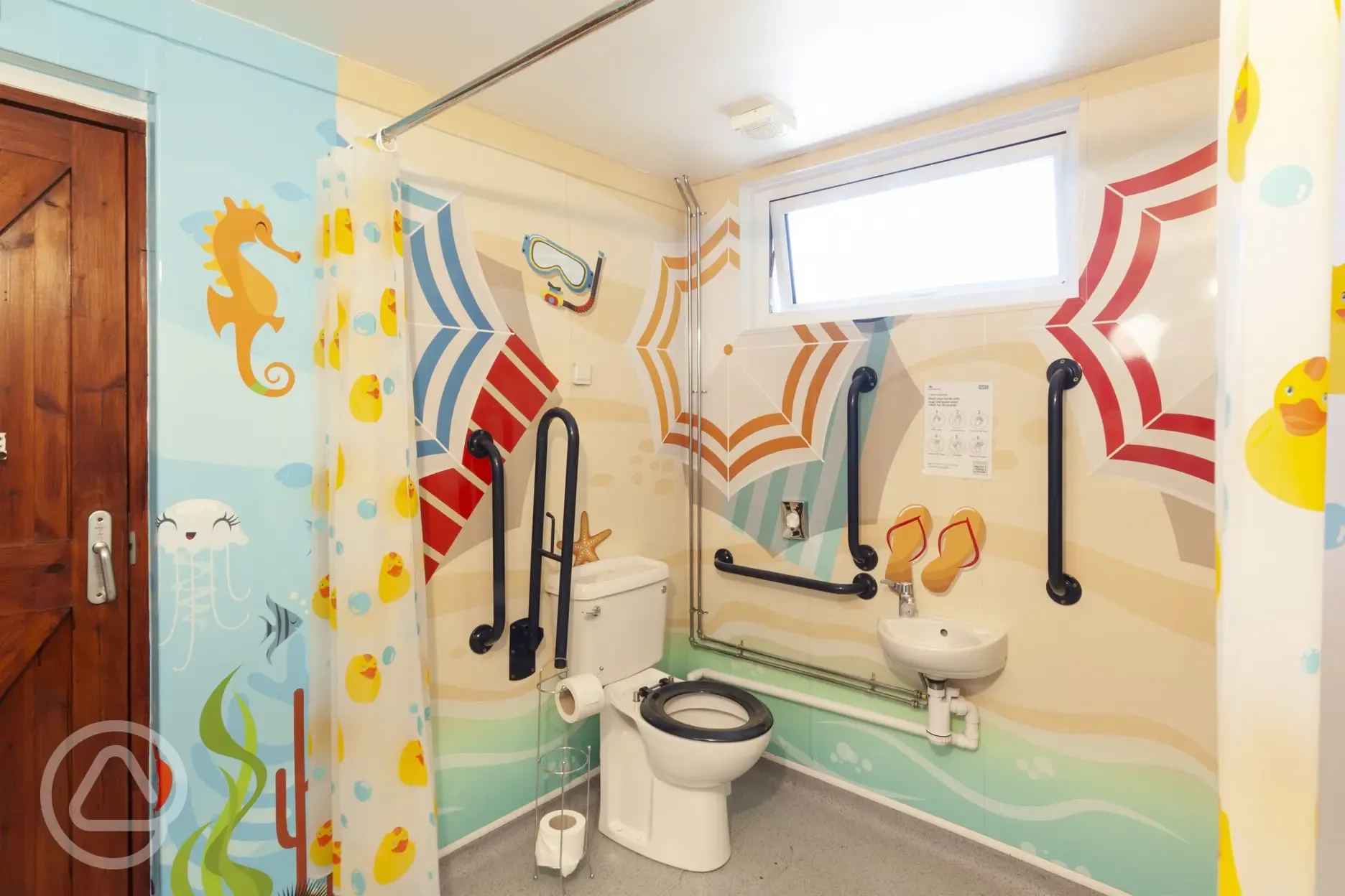 Family bathroom with a toilet, grab rails, and a sink