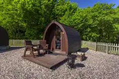 Camping pod with decking, chairs, and a fire pit
