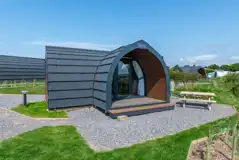 Gold glamping pod exterior with outdoor seating