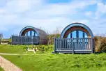 Silver glamping pods exterior with decking and outdoor seating