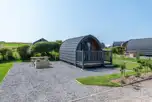 Bronze camping pod exterior with outdoor seating area, and sleeping up to four 