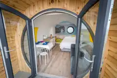 Silver glamping pod interior with double bed, sofa bed, kitchenette and seating