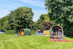 Wooden painted camping pods with deck areas and outdoor furniture Wooden painted camping pods with deck areas and outdoor furniture