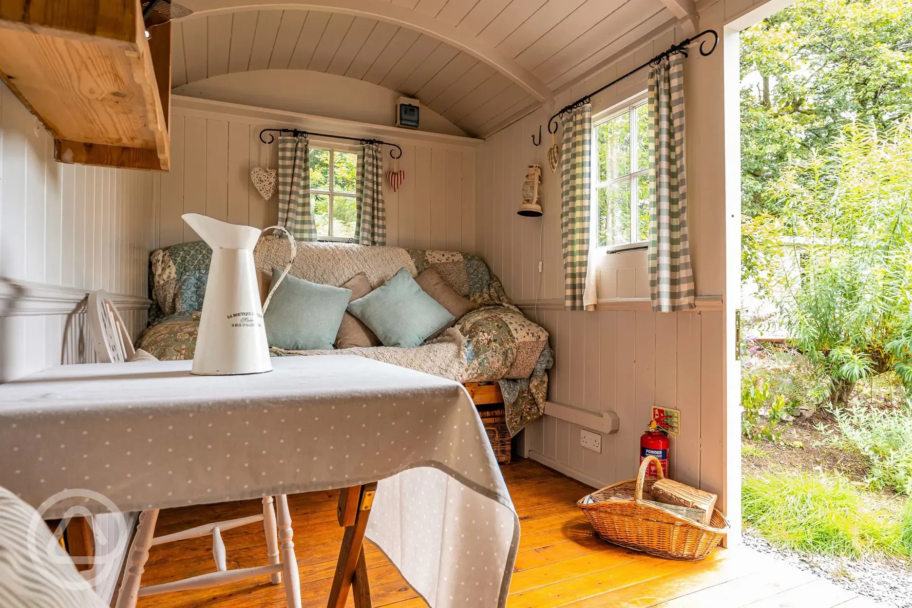 Shepherd's hut interior with a double sofa bed and bedding