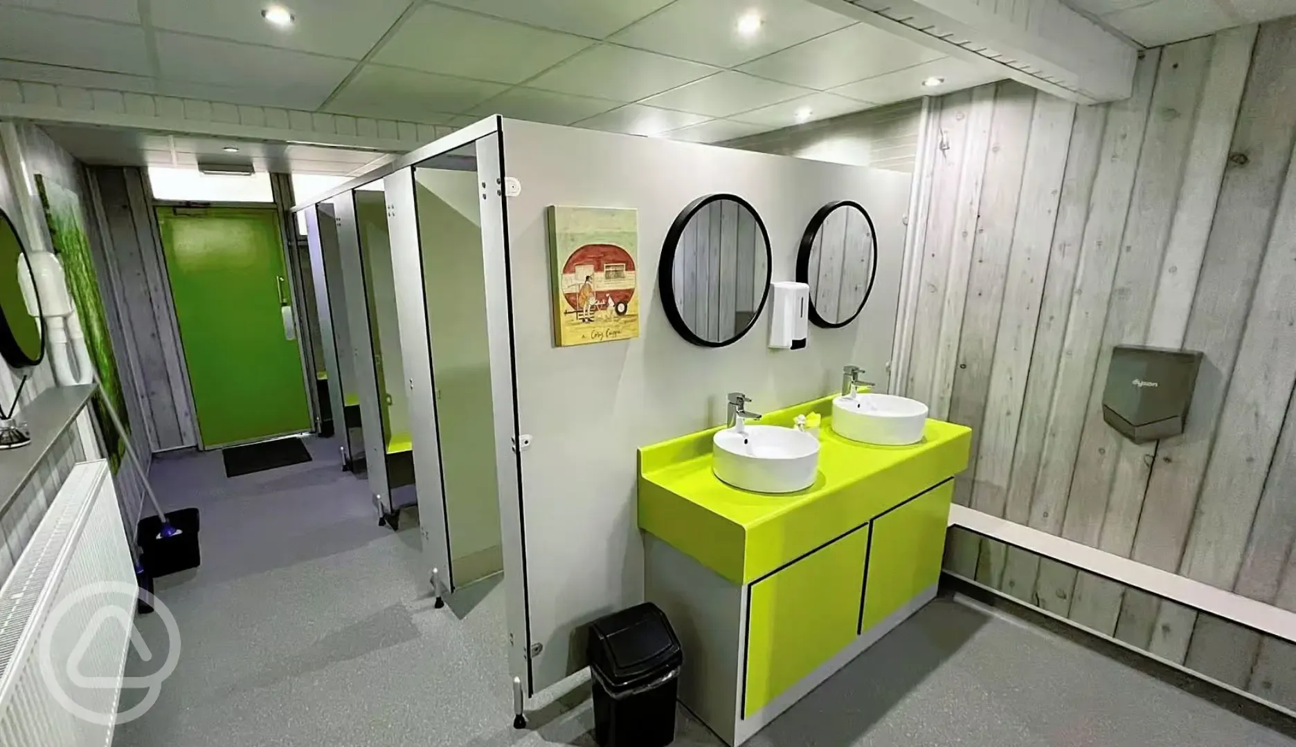 Toilet cubicles with two handwashing sinks, mirrors and hand dryers