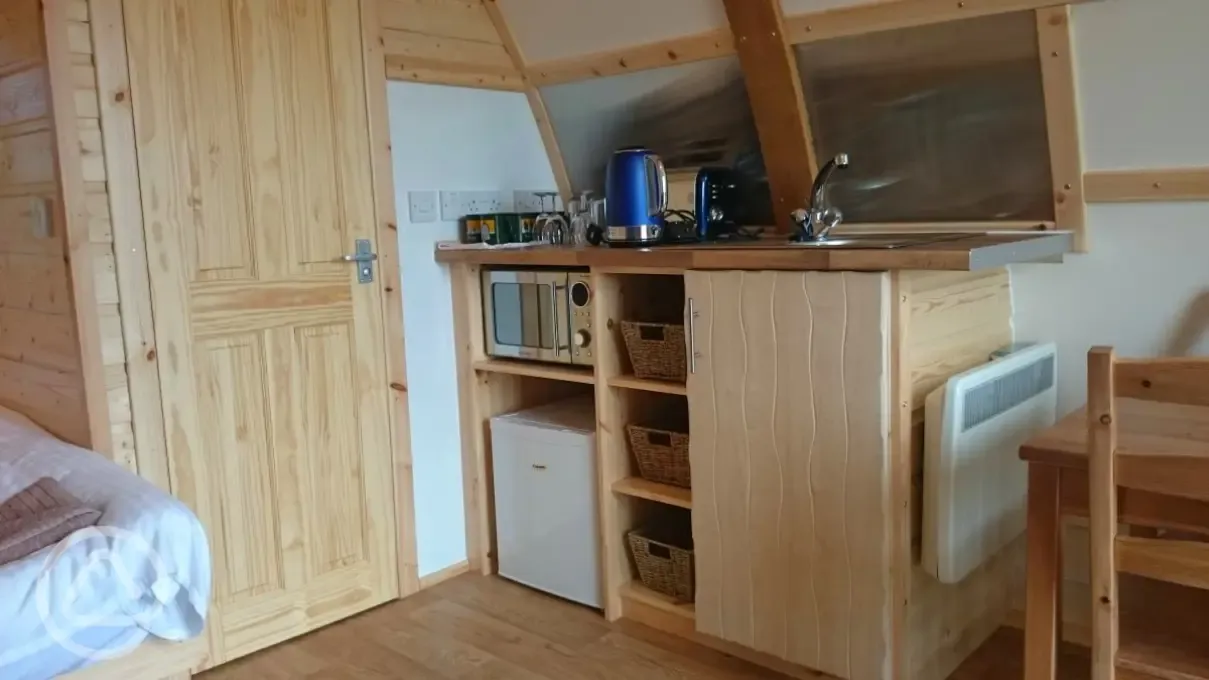 Fridge and kitchen inside Wigwam pods