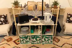 Bell tent interior with a double bed and two futons Bell tent interior with a double bed and two futons