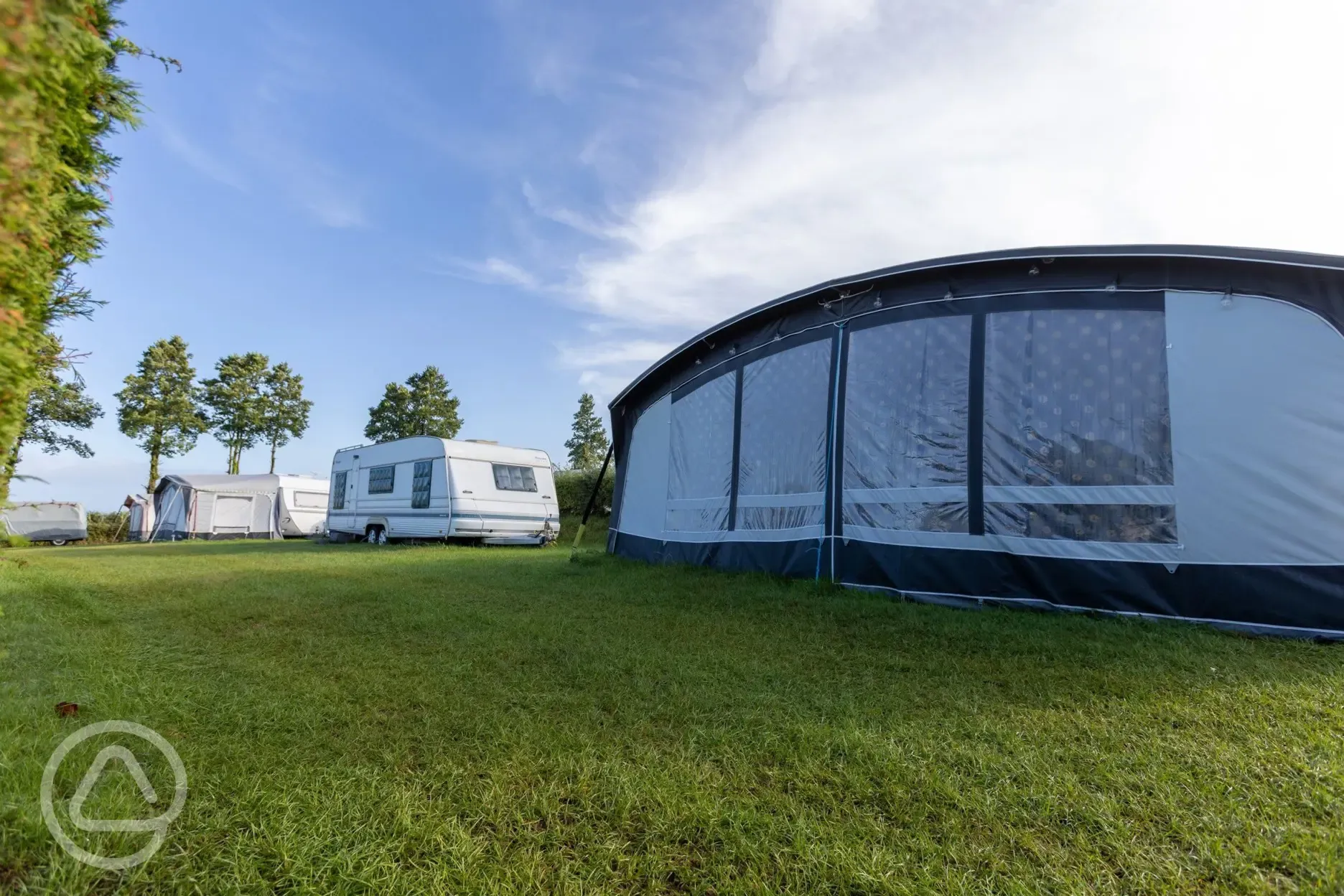 Caravans with awnings on electric grass pitches at Cornish Coasts