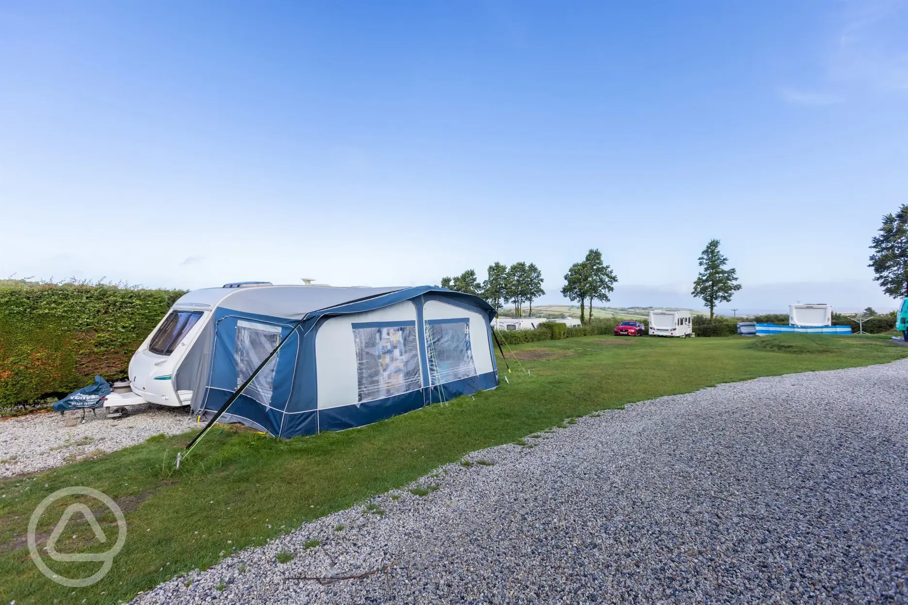 Caravan on electric grass and gravel touring pitch with an awning