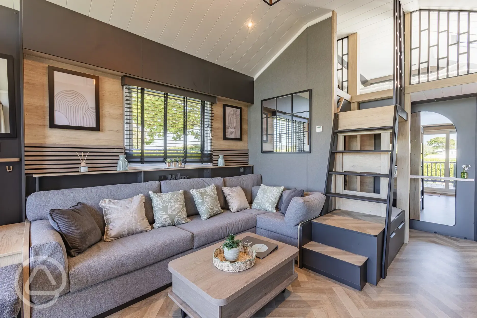 Ensuite glamping cabin interior with kitchen, sofa bed, king size and twin beds