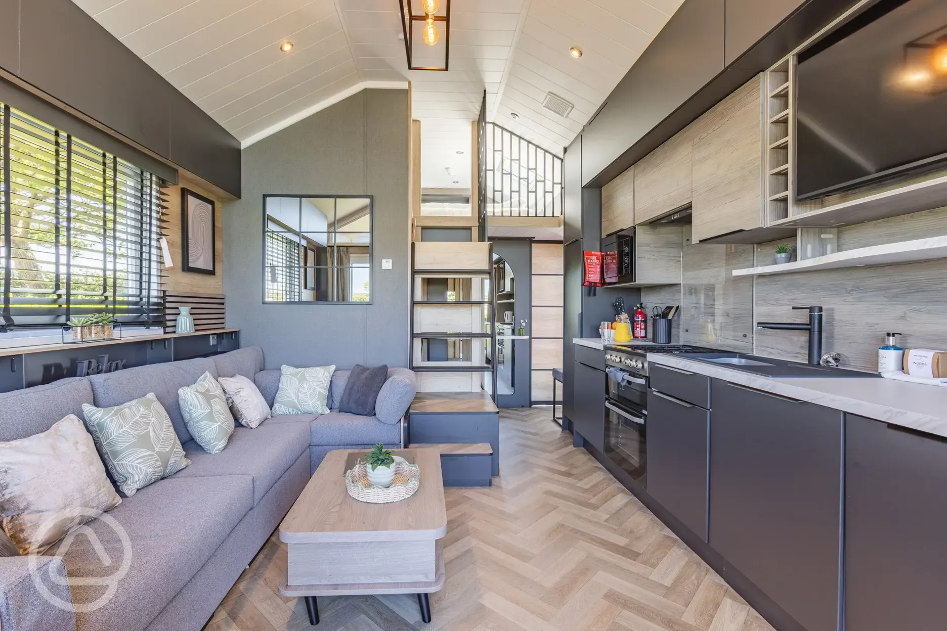 Ensuite glamping cabin interior with kitchen, sofa bed, king size and twin beds