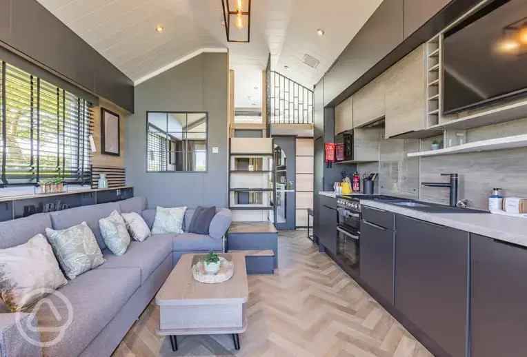 Ensuite glamping cabin interior with kitchen, sofa bed, king size and twin beds