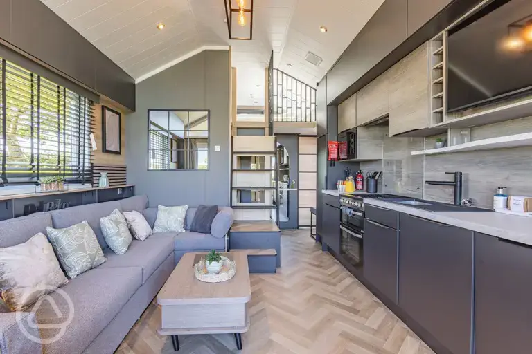 Ensuite glamping cabin interior with kitchen, sofa bed, king size and twin beds