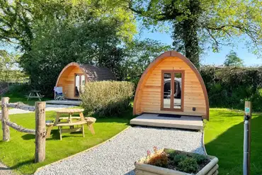 Glamping pods with outdoor decking and picnic benches