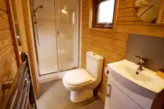 Ensuite toilet, shower, and handwashing sink in the deluxe mega glamping pod