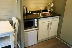 Kitchenette with a kettle, mircrowave, and fridge in the premier pods