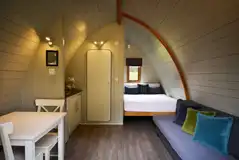 Premier glamping pod interior with a double bed and double sofa bed 