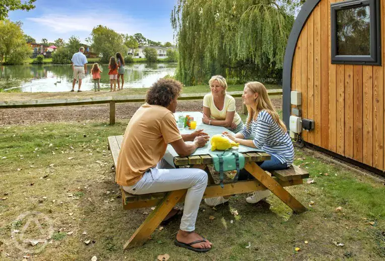 Camping pods outdoor seating and lakeside views