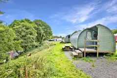 Riverside camping pods with a sheltered porch