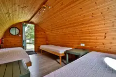 Riverside camping pod interior with bedside tables